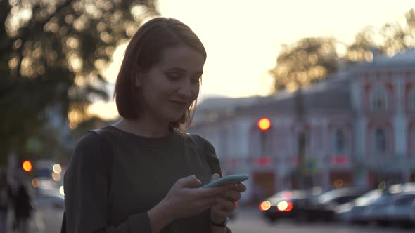 Closeup Young Woman's Hands Holding Mobile Phone with Touch Screen Outside at Street Road and City