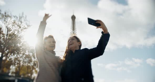 Happy Loving Mother and Daughter Taking a Selfie Photo on a Smartphone and Cuddling Together, on the