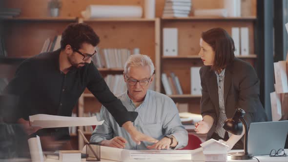 Senior Architect Working in Team with Young Colleagues in Office