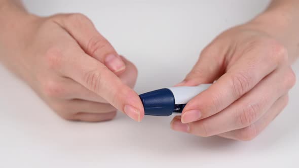 Caucasian Woman Doing a Glucose Test Using a Pen Lancet