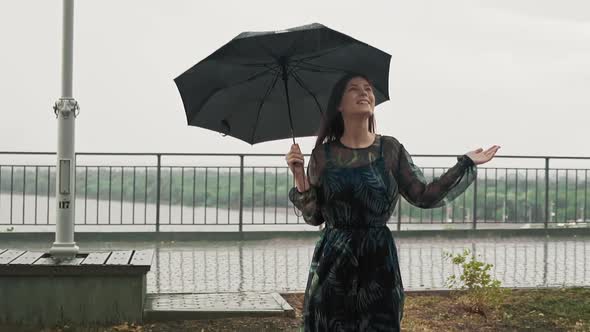 Woman Hides Under Black Umbrella Enjoying Rainy Weather