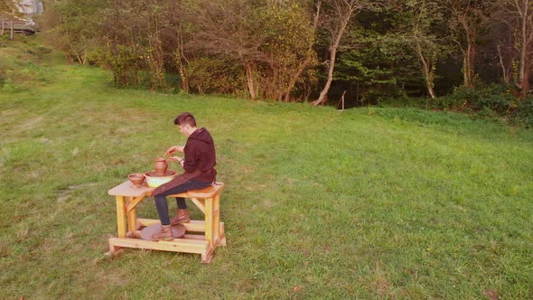 Aerial Orbital Snapshot of Ceramic Artist Pottery Concentrated on Work with Wheel Pot Clay Outdoor