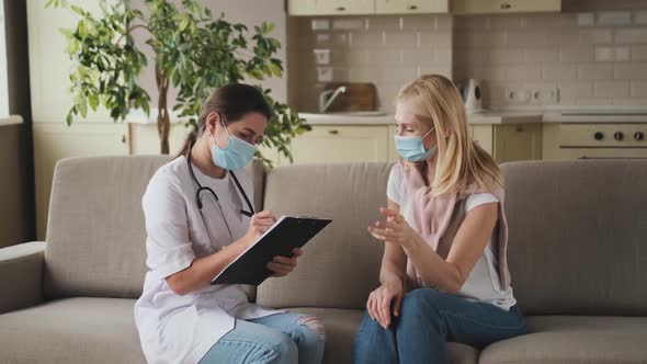 Woman Doctor Help Middle Aged Woman During Homecare Medical Visit with Mask on Face Female Nurse