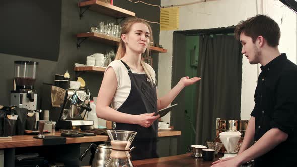 Female Barista Talking To Customer in a Cafe, Taking Order