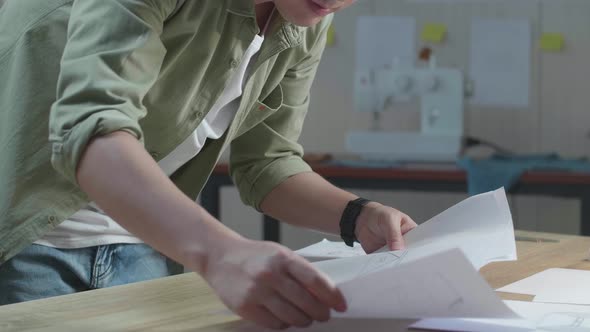 Close Up Of Asian Man Designer Arranging The Bag Sketching Layout Bond At The Office