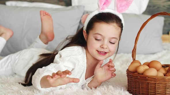 Playful girl putting eggs in the easter basket