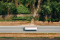 Aerial shot of semi-truck driving along the highway through countryside landscape, drone pov - PhotoDune Item for Sale