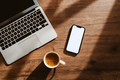 Cup of coffee, laptop computer and smartphone with blank white mockup screen on office work desk - PhotoDune Item for Sale