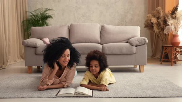 Afro American Woman Reads Book with an Interesting Fairy Tale to Little Girl