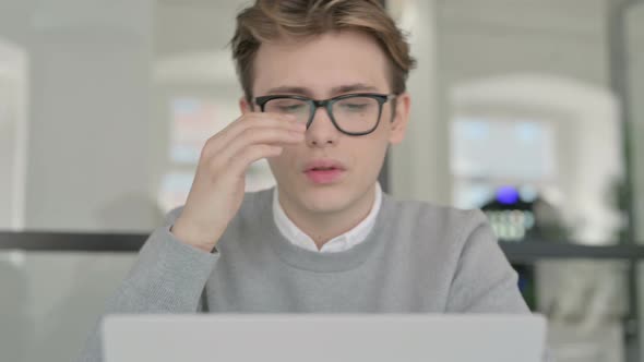 Close Up of Young Man with Headache Working on Laptop