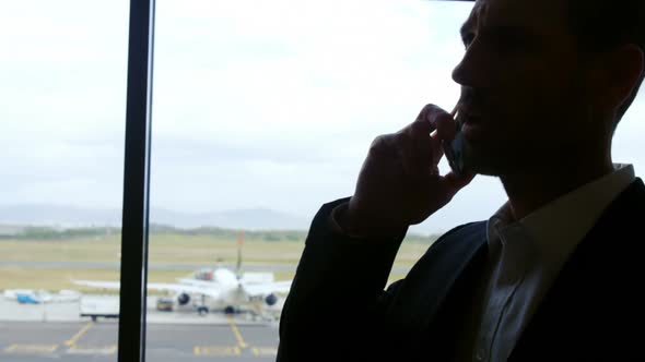 Businessman talking on mobile phone at airport