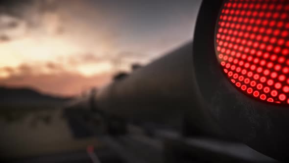 Locomotive with tank wagons carrying liquid cargo passing a railway crossing.