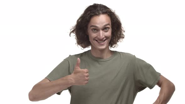 Handsome Man with Wavy Hairstyle Wearing Casual Tshirt Showing Thumbsup and Smiling Pleased