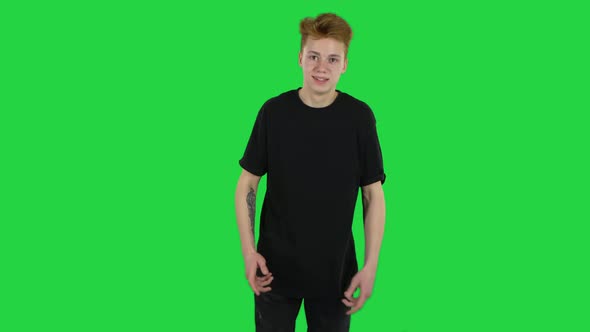 Ginger Teenager Boy with a Tattoo Is Having Fun on a Green Screen