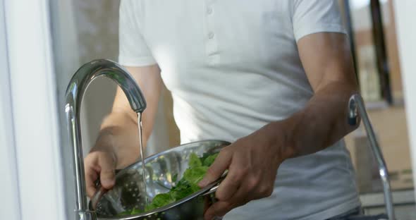 Senior man cleaning vegetable in kitchen 4k