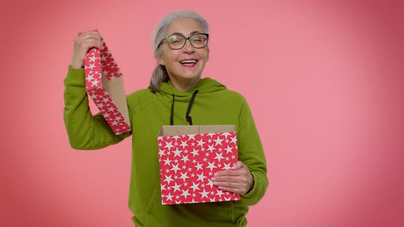 Cheerful Senior Grandmother Woman Opening Gift Box and Smiling Joyfully Satisfied with Nice Present