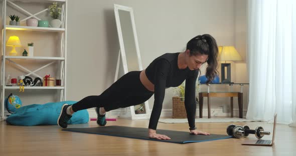 Wide Shot of Focused Sportswoman Doing Push Ups on Exercise Mat at Home. Young Slim Caucasian Woman