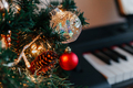 branches of a decorated Christmas tree on the background of piano keys. - PhotoDune Item for Sale