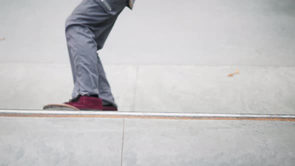 Skater Practicing in the Autumn Concrete Skate Park Making Tricks and Rides in Ramp