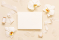Wedding card near white orchid flowers and silk ribbons on light yellow, mockup - PhotoDune Item for Sale