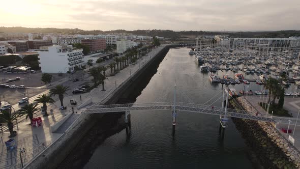 Broll cinematic aerial view of the lift bridge and boatyard at Marina de Lagos Algarve Portugal.