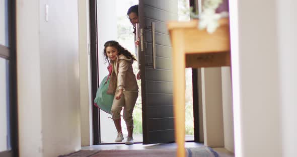 Mixed race mother and daughter enter the house