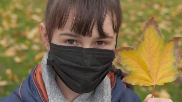 Masked teenager in autumn.