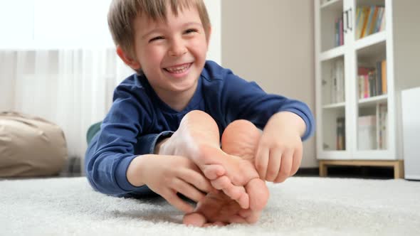 Funny Laughing Boy Lying on Mother and Tickling Her Feet