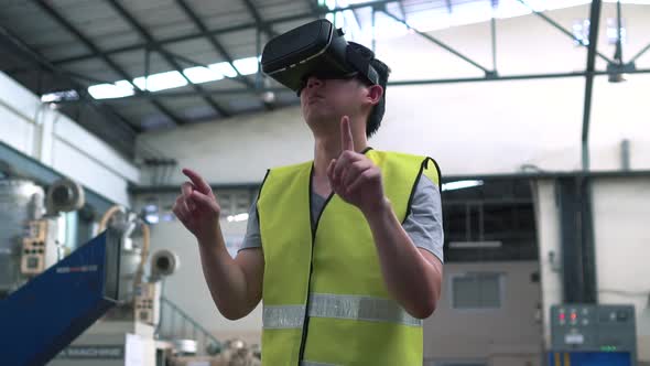 Industrial Factory Worker Wearing VR Goggle Touching in Virtual Reality World Inside Factory