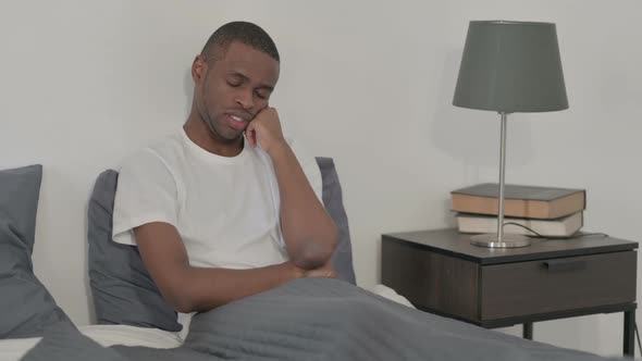 African Woman Taking Nap While Sitting in Bed