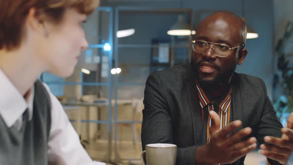 African American Businessman Talking with Colleague at Night Meeting