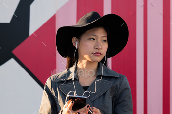 young asian woman listening music from her phone