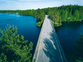 Aerial view of bridge road over blue river or lake with green woods in Finland - PhotoDune Item for Sale