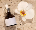 Glass Dropper bottle on stone near white orchid flower top view, Cosmetic Mockup - PhotoDune Item for Sale