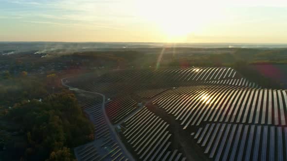 Aerial Drone Footage. Radial Flight Over Solar Panel Farm at Sunset Autumn Season.