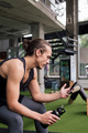 sportsman holding a bottle consulting phone at gym - PhotoDune Item for Sale