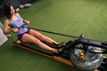 sporty woman training with a water rowing machine - PhotoDune Item for Sale