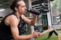 man drinking water and looking the phone at gym - PhotoDune Item for Sale