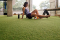 sportswoman massaging her legs with a rolling pin - PhotoDune Item for Sale