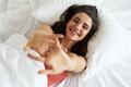 Top view of relaxed young woman keeping arms outstretched while lying in bed - PhotoDune Item for Sale