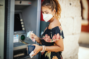 ve mask while taking money from ATM machine during Covid-19 pandemic.
