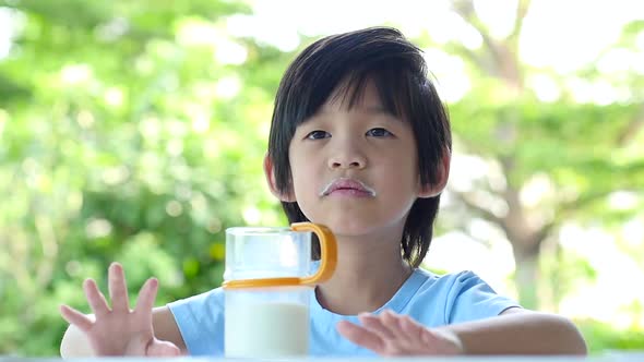 Unhappy Asian Child With Glass Of Milk