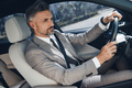 Handsome mature man in formalwear looking confident while driving a car - PhotoDune Item for Sale