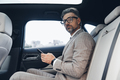 Thoughtful mature businessman holding smart phone while sitting in the car - PhotoDune Item for Sale