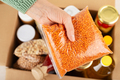 Plastic container with lentils in female hand on emergency food box background - PhotoDune Item for Sale