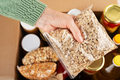Plastic container with rolled oats in female hand on emergency food box background - PhotoDune Item for Sale