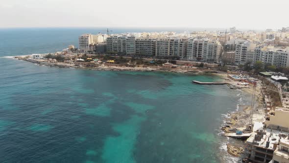 Aerial  Push In Wide Shot Of Exiles Bay in Sliema Malta