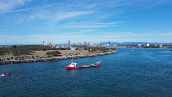 Revealing large coastal maintenance ship positioned in a city seaway with a urban skyline backdrop i