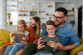 Happy family spending time at home with digital devices together. Technology people fun concept - PhotoDune Item for Sale
