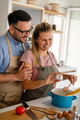Young happy couple is enjoying and preparing healthy meal in their kitchen together - PhotoDune Item for Sale